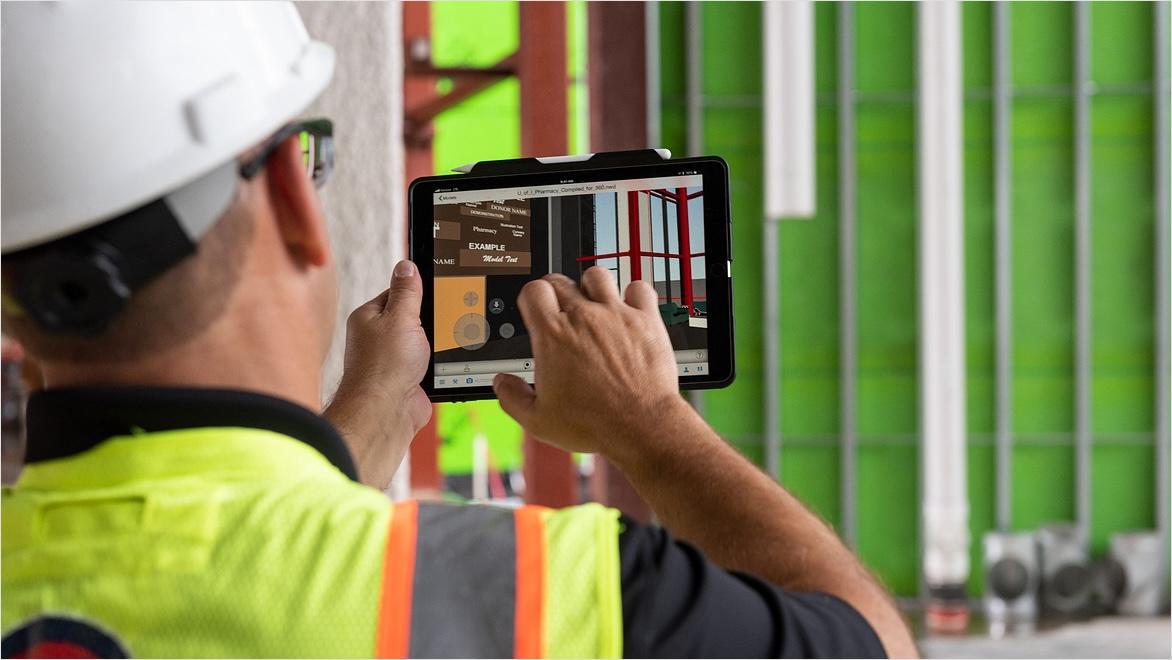 Construction manager using project management software on a tablet at a jobsite