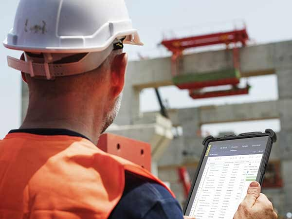 Construction supervisor using tablet to communicate with IT support